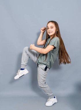 Neşeli küçük kız gülüyor. Küçük kız dövüş teknikleri gösteriyor.