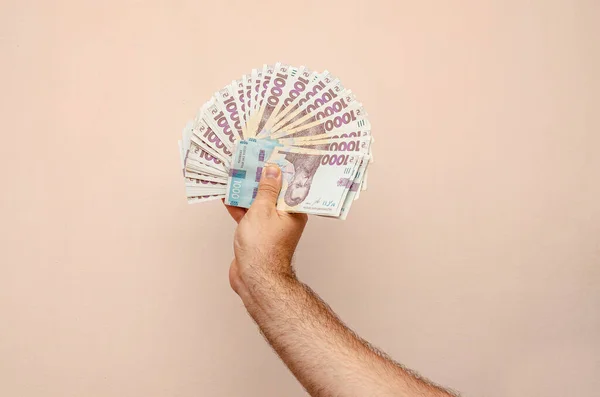 Man hand holding Ukrainian hryvnia bills of 1000 hryvnias. War in Ukraine, economic problems, earnings