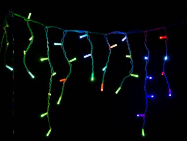 Siyah arka planda renkli Noel çelenkleri