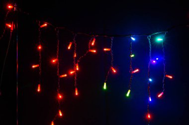 Siyah arka planda renkli Noel çelenkleri