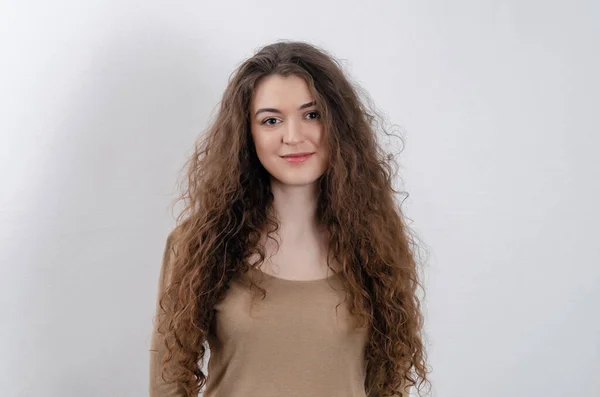 Girl Long Dark Curly Hair Smiling Looks Camera Gray Background — Φωτογραφία Αρχείου