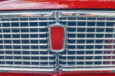 front grille of bright red Soviet retro car. The front of old red Lada car.