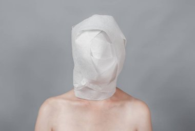 The head is wrapped in white toilet paper. Mummy, mental health concept
