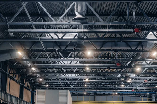 Metal trusses. Ceiling of large factory building with artificial lighting. Industrial background