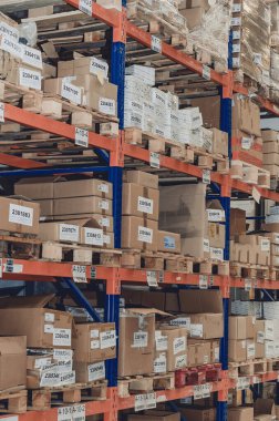 Industrial distribution, composition. Storage with high shelves. Rows of shelves with boxes at the factory.