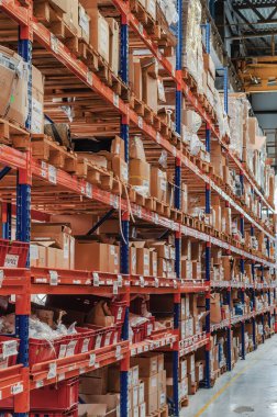 Industrial distribution, composition. Storage with high shelves. Rows of shelves with boxes at the factory.