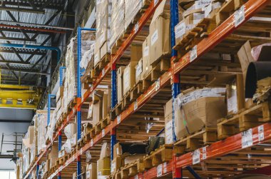 Industrial distribution, composition. Storage with high shelves. Rows of shelves with boxes at the factory.