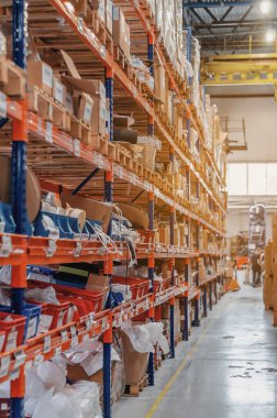 Storage with high shelves. Rows of shelves with boxes at factory. Industrial distribution, composition.