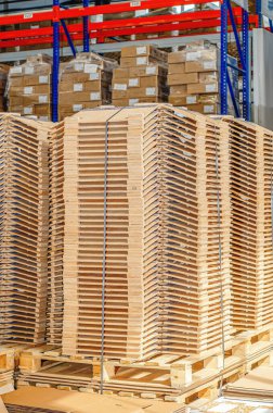Wooden parts in stacks in factory warehouse. Wooden parts for lighting devices. Vertical photo