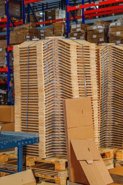 Wooden parts in stacks in factory warehouse. Wooden parts for lighting devices. Vertical photo