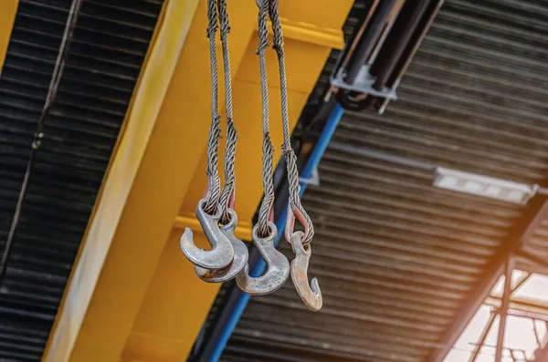 Metal hooks of lift in assembly shop. Lifting device, lifting hook at factory.