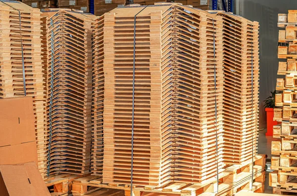 Wooden parts in stacks in factory warehouse. Wooden parts for lighting devices.