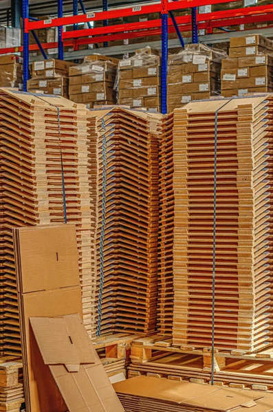 Wooden parts in stacks in factory warehouse. Wooden parts for lighting devices. Vertical photo