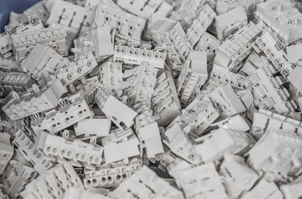 Pile of white electrical connection blocks for cables. Abstract industrial background