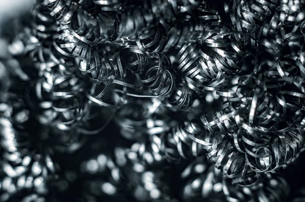 Iron metal shavings, curls, gray metal background. Macro shooting of metal processing, turning business.