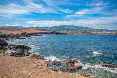 Kum, zümrüt okyanus, sahil, dağlar. Kanarya Adaları, İspanya. Tatil ve seyahat kavramı