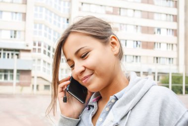 Tatlı genç kız cep telefonuyla konuşuyor.