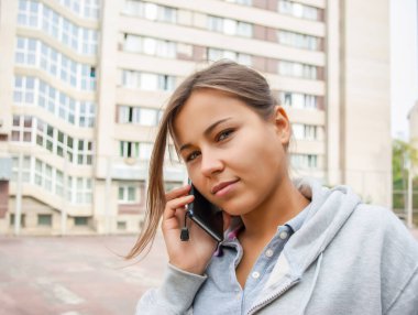 Tatlı genç kız cep telefonuyla konuşuyor.