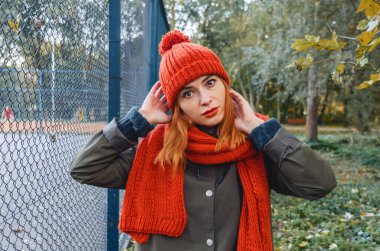 Atmosferik parlak sonbahar fotoğrafı. Şık kız ellerini başının yanında tutuyor. Moda görünümü