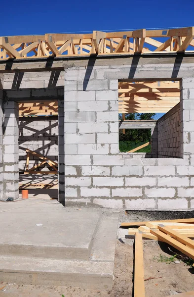用混凝土砌块 木制屋顶桁架 框架和混凝土门廊筑墙的在建房屋 — 图库照片