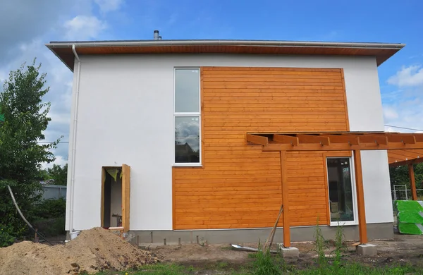 带庭院的新房子的外墙 将木料覆层 镶板和白色粉刷或石灰混合在一起 — 图库照片