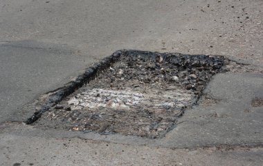 Yol inşaatı veya garaj yolu tamiri: çukurun temizlenmesi ve yeniden şekillendirilmesi yoluyla asfalt yolu tamir etmek.  