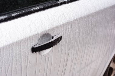 Buz çözücü araba kapıları ve kilitleri. Dondurucu yağmurdan, kışın buz fırtınasından sonra bir araba kapısının donmuş kilidinin yakın çekimi..