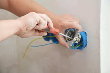 Elektrik prizi takılıyor, prizler yeni ev duvarına takılıyor.