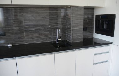 Mutfak lavabosu olan siyah beyaz bir mutfak masasına yakın plan..