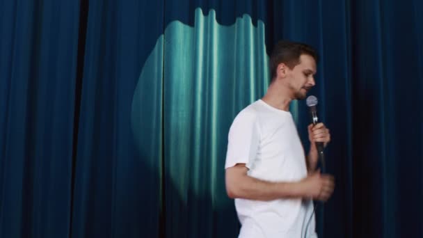 Un animado presentador en el escenario muestra stand-up y hace reír a la audiencia. — Vídeo de stock