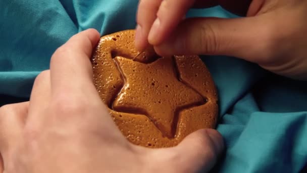 Mens hands scratch brown sugar candy with metal needle pattern in form of star — Stock Video