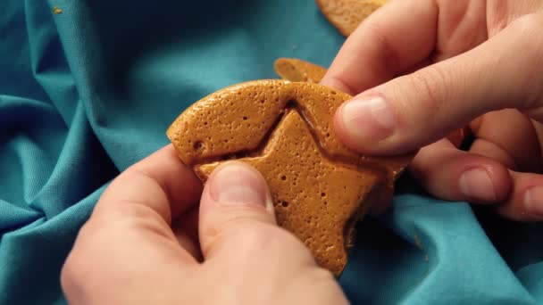 Heren handen breken suikerkoekjes snoep in de vorm van een ster. — Stockvideo