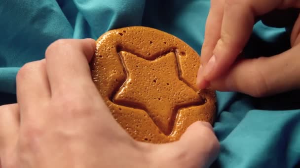 손으로 갈색 설탕 사탕을 긁어 내고 금속 바늘 무늬를 가진 별 모양의 사탕을 만든다 — 비디오