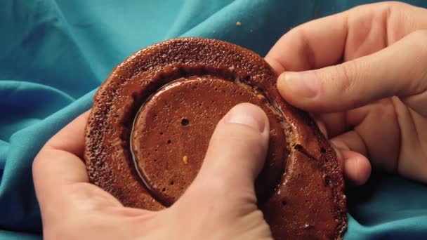 Le mani di uomini rompono la caramella di biscotti da zucchero nella forma di un cerchio. — Video Stock