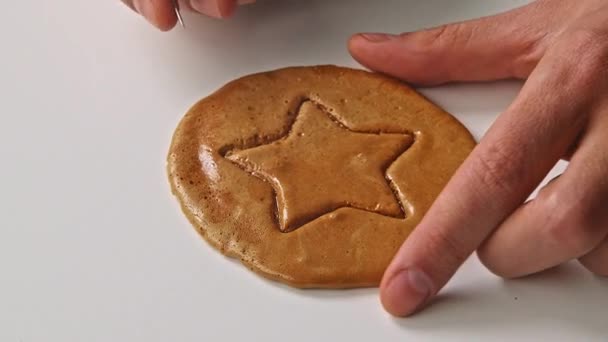 Le mani di uomini rompono la caramella di biscotti da zucchero nella forma di una stella. — Video Stock