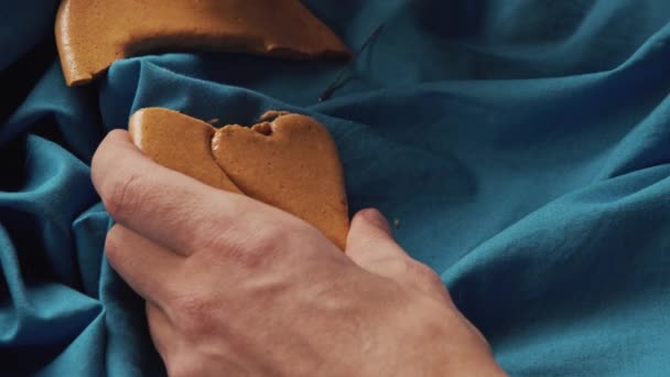 Erkek eli şeker kurabiyesi kalp şeklinde şeker kırar.. — Stok video