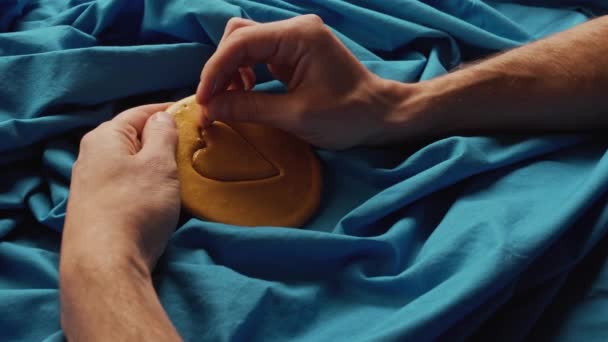 Männerhände kratzen braune Zuckerbonbons mit Metallnadelmuster in Herzform — Stockvideo