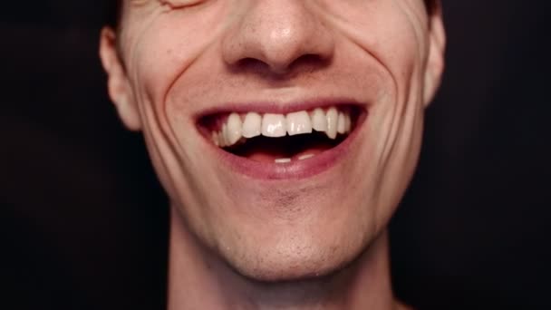 Człowiek z dużymi zębami i zmarszczkami. Kręci się, pokazuje język, uśmiecha i śpiewa pieśń — Wideo stockowe