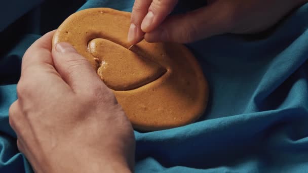 Mani degli uomini grattano zucchero biscotti caramelle a forma di cuore. — Video Stock