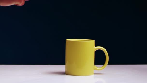 Mans mão quebra uma caneca de chá amarelo com líquido com um martelo de ferro — Vídeo de Stock