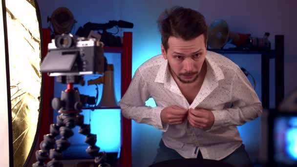 Чоловік готується до відеотрансляції на телефонній гудзиці та налаштовує зачіску. — стокове відео