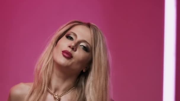 아름다운 여성 이 분홍색 배경으로 스튜디오에서 뮤직 비디오를 위해 노래를 부른다. — 비디오