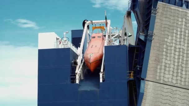 Barco salvavidas naranja fijado en enorme barco — Vídeos de Stock
