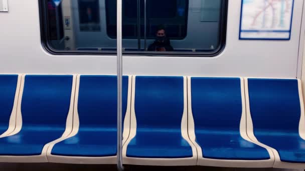 Homem com uma máscara preta cavalga em um carro do metrô e atira em assentos vazios — Vídeo de Stock