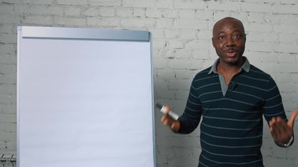 Profesor afroamericano lleva a cabo conferencia en línea con rotafolio y marcador — Vídeos de Stock