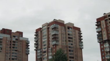 Üç eski apartmandan birinin çatısına yavaşça zum yap.