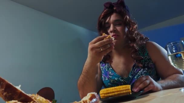 Man dressed in womans dress and makeup on face eats a huge sandwich – Stock-video
