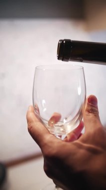 Close-up of pouring red wine from a bottle into glass