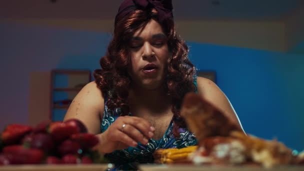Homme habillé en femme robe et maquillage sur le visage mange un énorme sandwich — Video