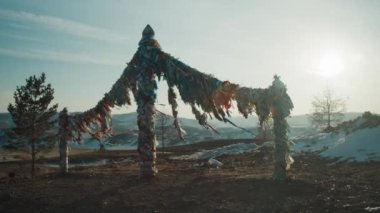 Wood with multi-colored ribbons of fabric. Religious place on Lake Baikal 
